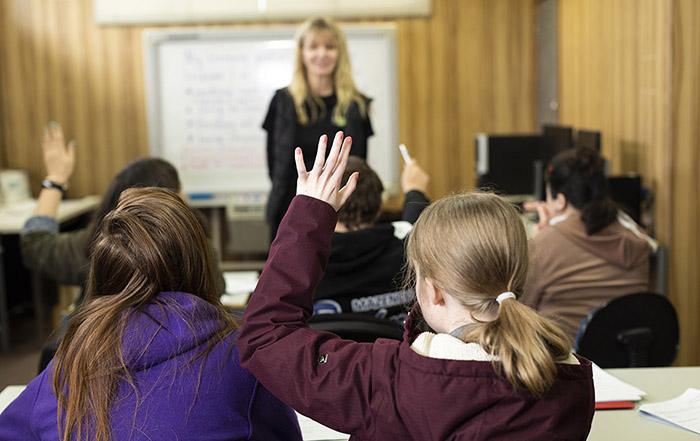 Student with hand up in classroom